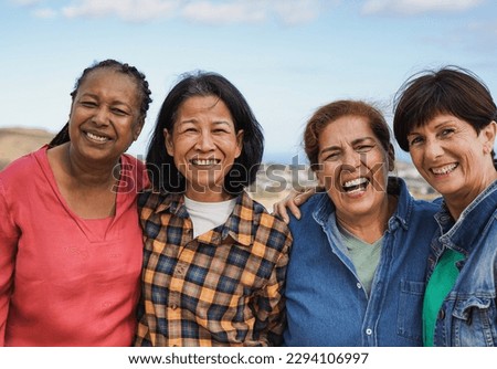Happy multiracial senior women having fun together smiling on camera outdoor - Elderly generation people hugging each other at home terrace Royalty-Free Stock Photo #2294106997