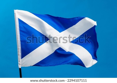 Scottish flag waving on blue background. Royalty-Free Stock Photo #2294107111