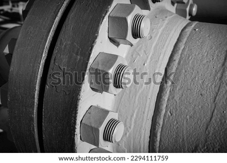Connecting bolts of the flange connection of the main gas pipeline, close-up, black and white picture