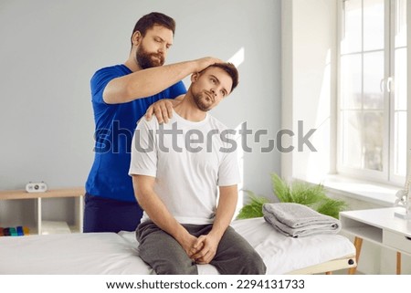 Man professional osteopath examining young man in modern hospital office. Chiropractor helping man patient with neck pain or other spine problems. Checkup, prevention examination, medicine concept. Royalty-Free Stock Photo #2294131733