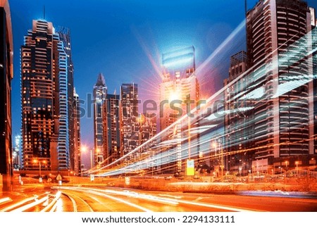 Abstract image of a modern night city with traces of headlights from cars on the highway on a background of skyscrapers