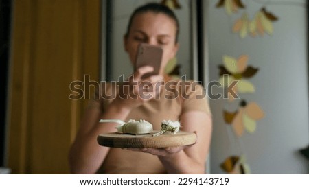 Young woman taking photos with tasty choco cake holding cake posing to camera
