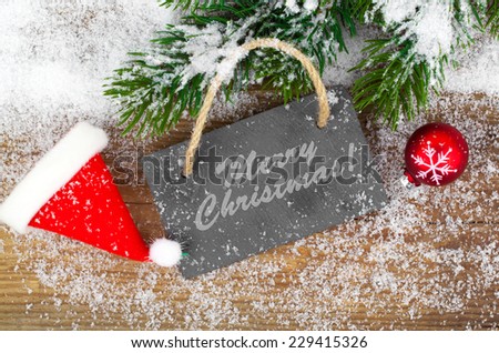 Black board of slate on rustic wooden background with snow