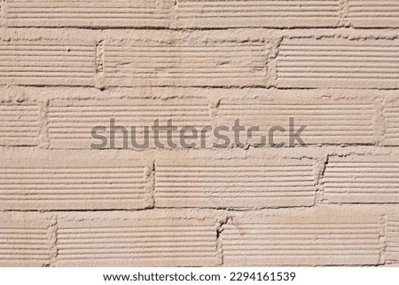 A light colored painted cheap brick wall