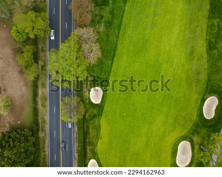 An aerial view over a pristine golf course on Long Island, New York during a beautiful day with blue skies and white clouds. No one was playing golf today.