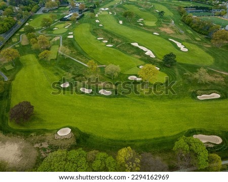 An aerial view over a pristine golf course on Long Island, New York during a beautiful day with blue skies and white clouds. No one was playing golf today. Royalty-Free Stock Photo #2294162969