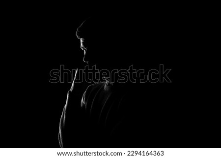 Male silhouette on a black background. A man stands thoughtfully on a black background Royalty-Free Stock Photo #2294164363