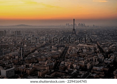 Aerial view of Paris at sunset with the Eiffel Tower and La Défense business district in the background, as seen from the Tour Montparnasse, France