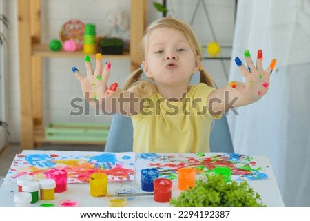 Girl paint fingers drawing baby painting hand therapy children art play. Kids have fun and create picture. Palms of different colors. Sensory development and experiences