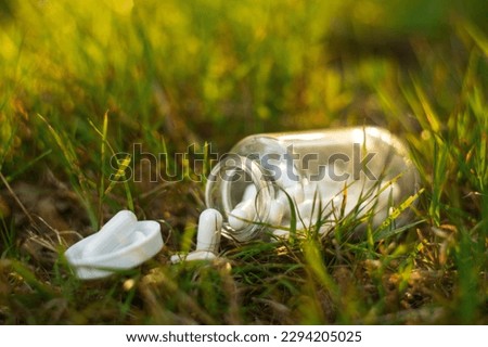 A glass bottle with scattered medicines on the ground.Drug overdose. Loss of medication.
