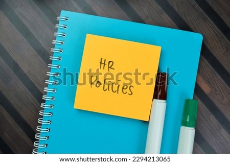 Concept of HR Policies write on sticky notes isolated on Wooden Table.