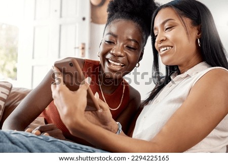 Have you seen this. Shot of two young friends using a phone while spending time together at home. Royalty-Free Stock Photo #2294225165