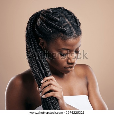 Strong hair doesnt let go. Cropped shot of an attractive young woman posing in studio against a brown background.