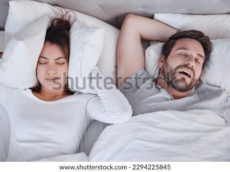Make it stop. Shot of a young woman struggling to sleep with her boyfriends snoring at home. Royalty-Free Stock Photo #2294225845