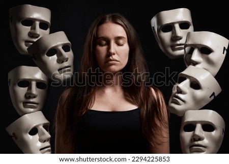 Im in control of my own emotions. Studio shot of a woman standing with her eyes closed while surrounded by masks. Royalty-Free Stock Photo #2294225853