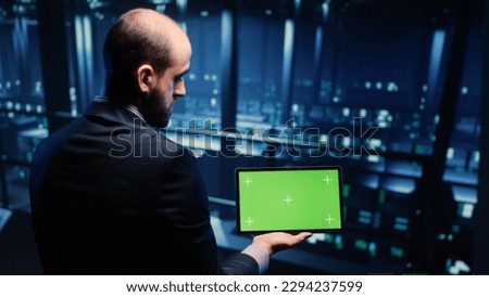 IT administrator running greenscreen display on tablet, using cloud computing in render farm. System technician working with isolated template and chroma key copyspace, artificial intelligence. Royalty-Free Stock Photo #2294237599