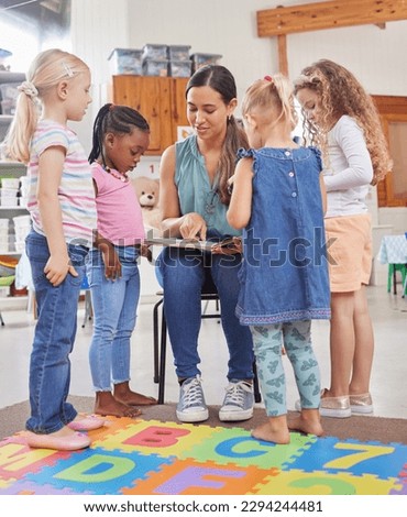 I love a good book as much as they do. Shot of a young woman reading to her preschool students. Royalty-Free Stock Photo #2294244481