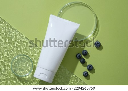 Top view of an empty label tube arranged with empty petri dish and acrylic sheet. Natural organic beauty cosmetic product mockup of Blueberry (Vaccinium Corymbosum) extract