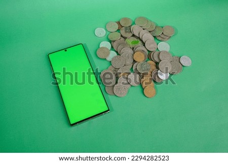 business finance. save money for investment concept coins with smart phone mockup isolated green background