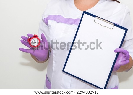A woman points with a finger at a tablet for paper in her hands