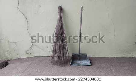 broom and cleaning beam against wall background