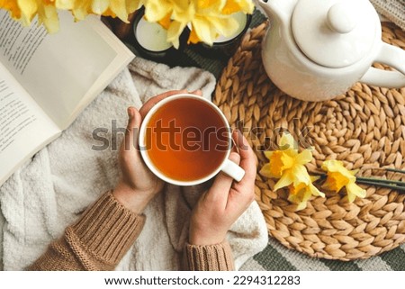 Cup of tea in hands top view, good morning concept.