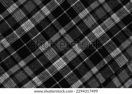 Black and white texture of a plaid fabric from a factory fabric for clothes. checkered clothes background.