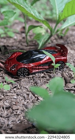 Photo of a red toy vehicle on a field of grass

