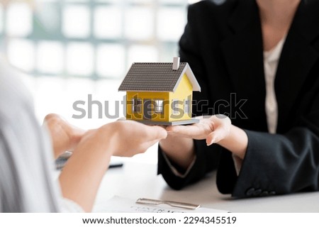 Close-up shot of a real estate agent or realtor meeting with her client, giving new house to her customer.	