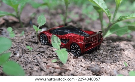 Photo of a red toy vehicle on a field of grass