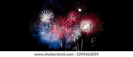 Red, white, and blue fireworks light up the night sky, patriotic celebration, New Years Eve or Independence Day. Shallow depth of field.  Royalty-Free Stock Photo #2294362059
