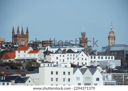Saint Peter Port skyline on the island of Guernsey in the Channel Islands, with traditional buildings and towers rising up into the sky. 