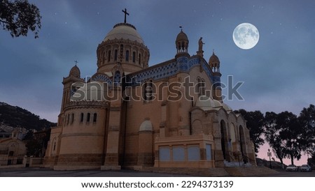 Notre Dame d'Afrique (English: Our Lady of Africa), the famous Catholic basilica in Algiers, Algeria. Night picture with a beautiful full moon. Symbol of Algiers.