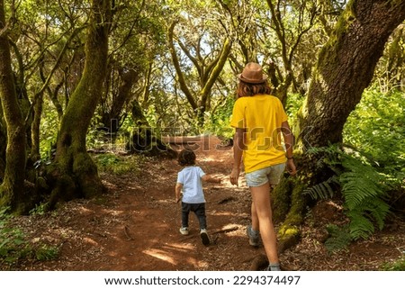 Mother and son walking in La Llania on El Hierro, Canary Islands. On a path of laurel from El Hierro in a lush green landscape