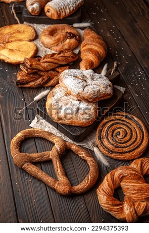 Wallpaper from different types of pastries on brown boards. For decoration of bakery sales outlets. Bakery products. Fresh bakery. Royalty-Free Stock Photo #2294375393