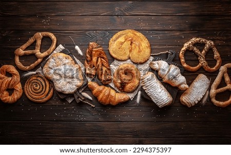 Wallpaper from different types of pastries on brown boards. For decoration of bakery sales outlets. Bakery products. Fresh bakery. Royalty-Free Stock Photo #2294375397