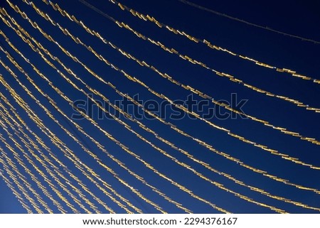 Abstraction blurred movement lights garlands. Golden lights of a blurred garland on the background of a purple blue sky. The concept of a night holiday night. Designer background of the New Year.