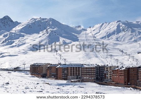 Ski lifts heading toward the top of the snow-capped mountains of Grandvalira from Pas de la Casa (Andorra).