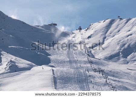Ski lifts heading toward the top of the snow-capped mountains of Grandvalira from Pas de la Casa. Royalty-Free Stock Photo #2294378575