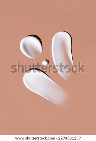 cosmetic smears of creamy texture on brown background Royalty-Free Stock Photo #2294381259