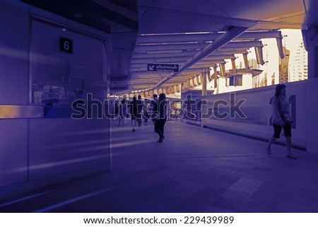 crowd silhouette of people crossing the hallway inside modern railway hub building