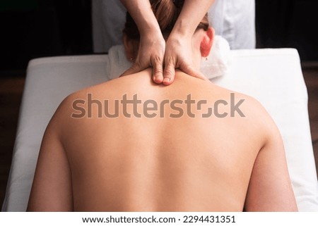 masseur massaging back and shoulder blades of young woman on massage table on white background. Concept of massage spa treatments. body relaxation procedures. Close-up Royalty-Free Stock Photo #2294431351