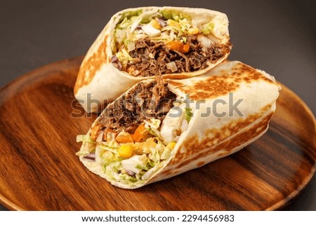 Burrito with pulled beef, Classic Mexican burrito with pulled chicken meat, black beans, pico de gallo and grilled wheat tortilla.