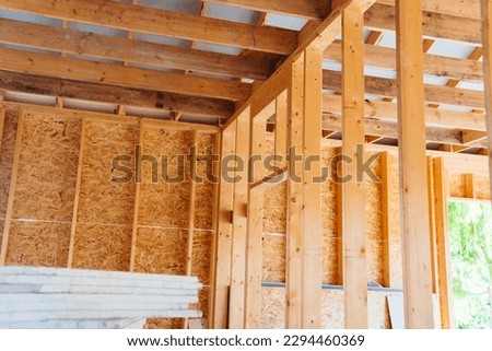 The internal structure of a block wooden house consists of wooden bars treated with an antiseptic and insulation. The parts are fastened on a wooden frame. Royalty-Free Stock Photo #2294460369