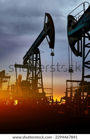 Prairie Oil Pump Jacks. One pump jack producing oil. Oil pumps at sunset, industrial oil pumps equipment. Sunset and darkness.