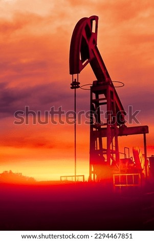 Oil pumps at sunset, industrial oil pumps equipment. Sunset and darkness. Oil field in the fog. Red Blue toning. Crisis in the oil production industry dramatic concept Abstract image