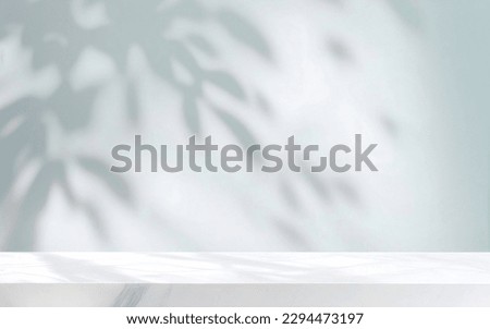 Minimalistic light background with blurred foliage shadow on a light blue wall. Beautiful background for presentation with with marble floor. Royalty-Free Stock Photo #2294473197