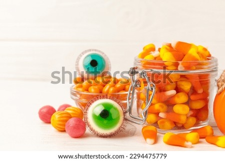 Halloween candy on a white background. coffee corn and sazar skull.Halloween holiday background with jack o lantern pumpkin, candy corn and decorations.Top view.Flat lay. Place for text.