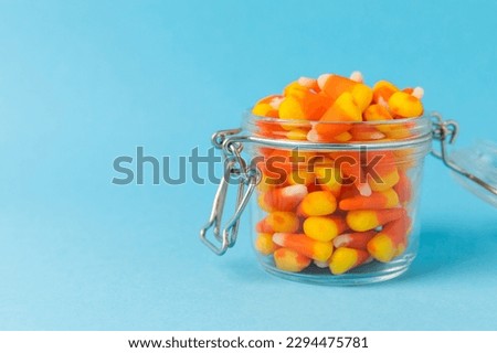 Halloween candy on a bright blue background. corn and pumpkin coffees, marmalade.Halloween holiday background with jack o lantern pumpkin, candy corn and decorations.Top view.Flat lay. Place for text.