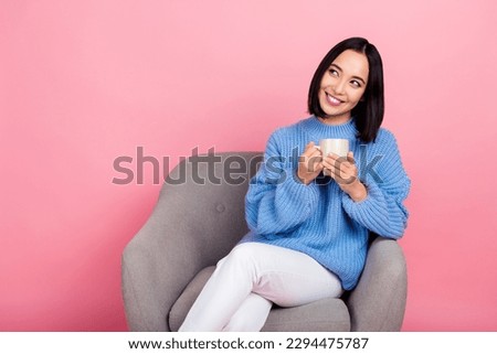 Portrait of cute lovely lady sit chair arms hold hot chocolate cup look empty space isolated on pink color background
